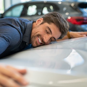 extended car warranty happy man hugging car 